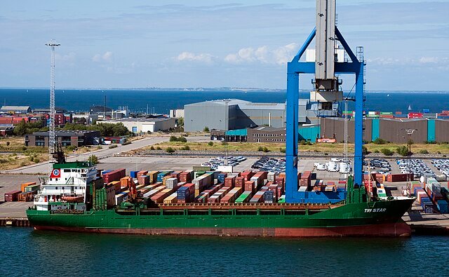 Shipping containers stacked at a U.S. port, representing global trade and import tariffs.