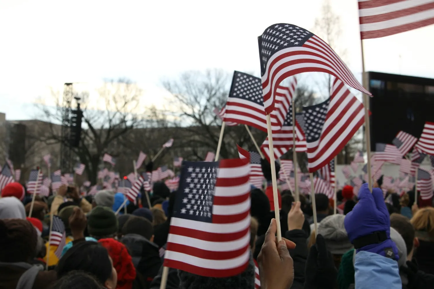 Crowd of Democrats waving American flags at a political rally in the United States.