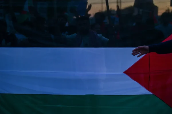 Palestinian flag during a gathering as reports emerge of a hostage’s body returned from Gaza to Israel.