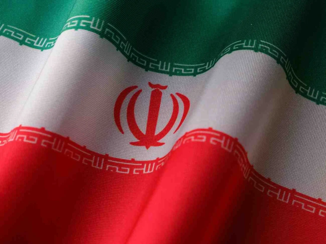 Iranian flag waving in close-up, symbolising Iran amid nationwide protests and rising tensions with the United States.