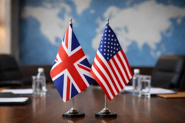 AI-generated image showing the flags of the United Kingdom and the United States side by side on a conference table, symbolizing UK–US diplomatic relations.