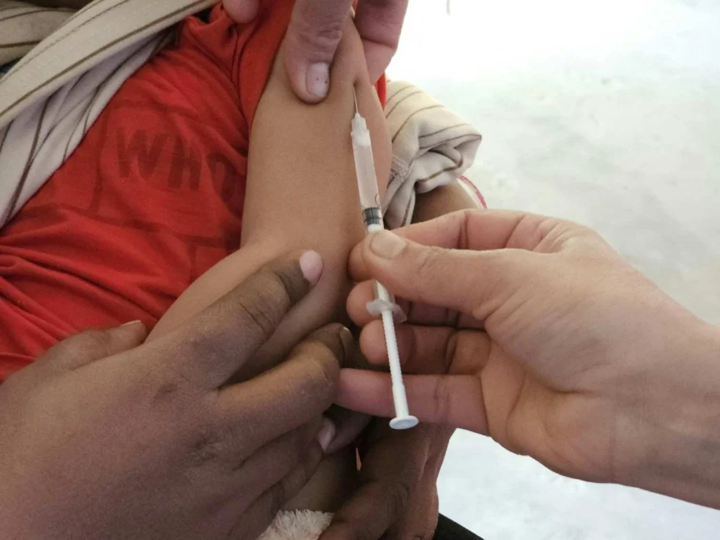 Child receiving MMR vaccination in upper arm to protect against measles