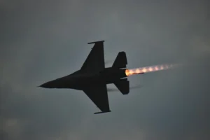 Silhouette of a fighter jet flying with afterburner flame visible against a cloudy sky, representative image for Pakistan air strikes near the Afghanistan border